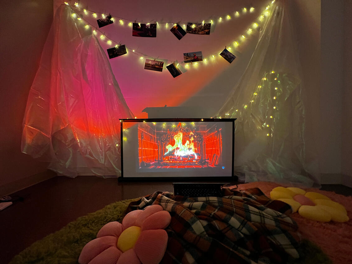 The "living room" sitting area in the back of the second room. Concept art for the animation is hung from the fairy lights above the projector.